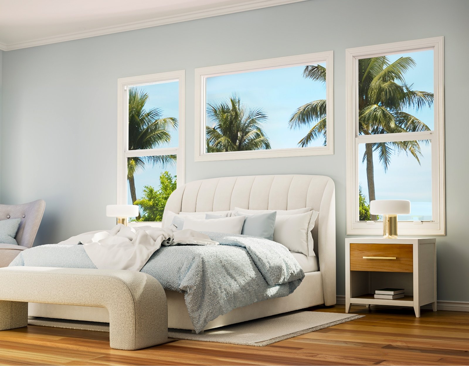 Bedroom with a wide picture window between two tall windows overlooking palm trees