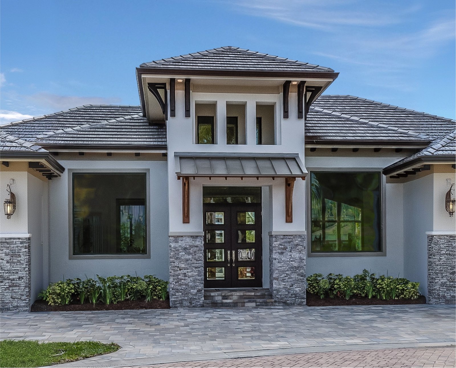 Home exterior with large dark-framed windows on either side of the front entrance